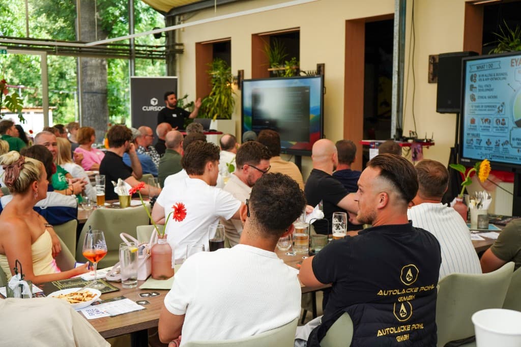 Eyad presenting at a Frankfurt Build Day with Cursor branding and a live code demo on screen
