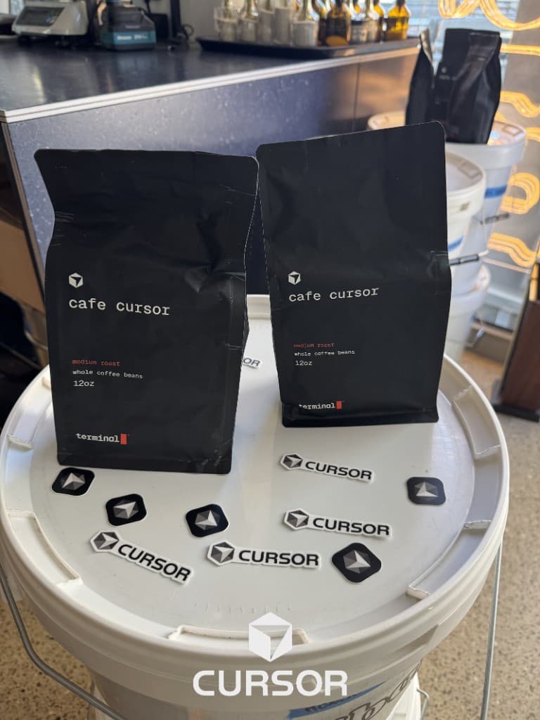 Café Cursor branded coffee bags and Cursor stickers at a community event