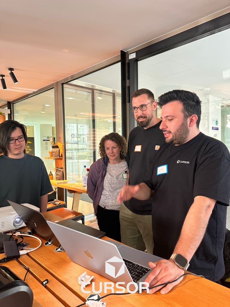 Eyad demonstrating Cursor on a laptop during a hands-on workshop